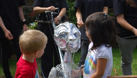 Two children look at the Star Child puppet