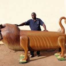 Man stands with carved lion shaped coffin
