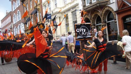 City Arts Carnival Troupe in orange costumes