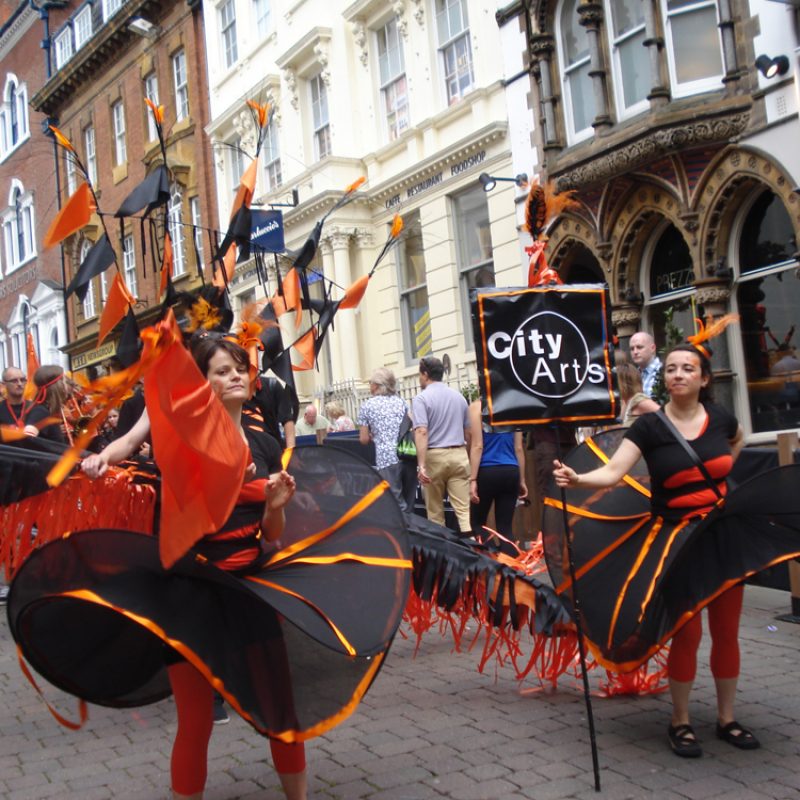City Arts Carnival Troupe in orange costumes