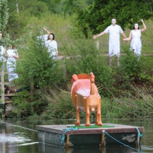 Lion coffin pulled across river on float