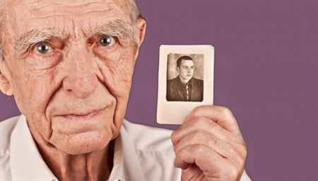 Elderly man holding photograph