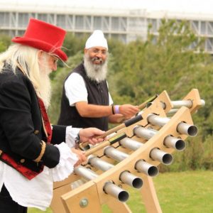 Two men play giant chimes