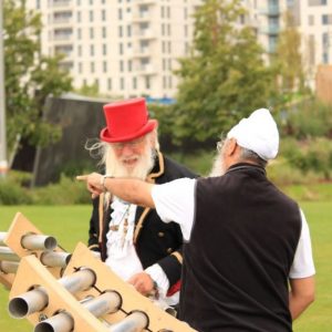 Two men play giant chimes