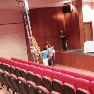 Man climbs ladder to lighting rig