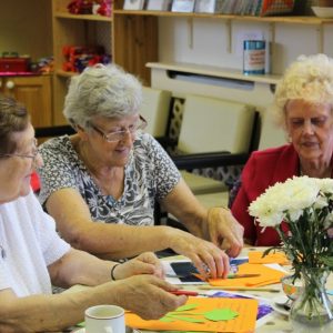 Older people create feathers for bird puppet
