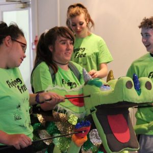 Young people operate dragon puppet