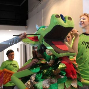 Young people operate dragon puppet