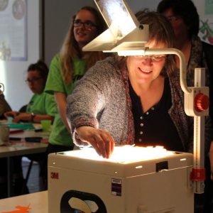 Woman puts puppets on overhead projector