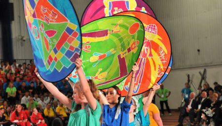 Performers hold painted silk discs