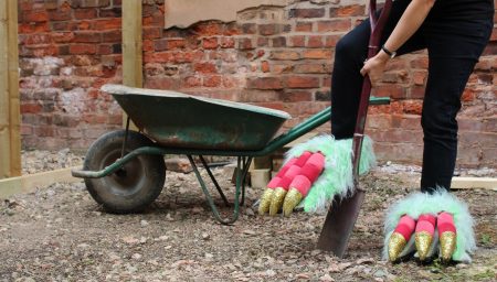 Woman wearing dragon feet digs with spade