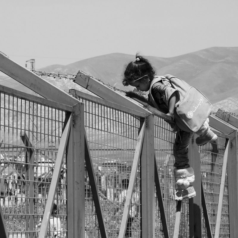 Photo of young girl climing over fence