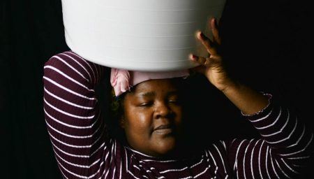 Art photograph of woman carrying bucket