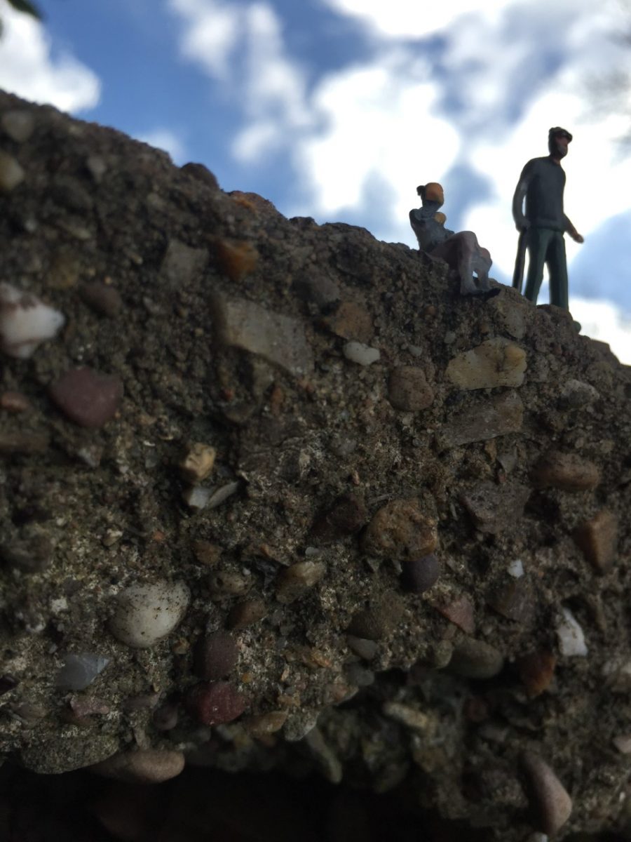 Miniature figurines appear to stand on a cliff face 