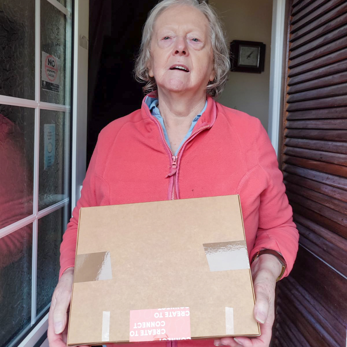 Older woman taking delivery of an art pack