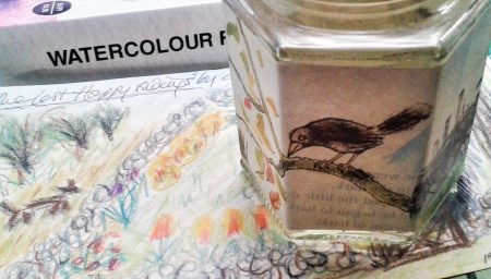 Jar with illustrated wrapper, sat on top of a pencil drawing of a field.