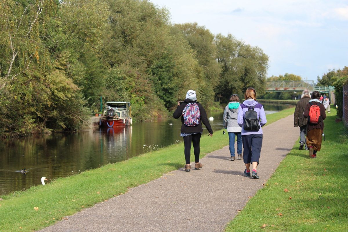 People walk down a canal tow-path