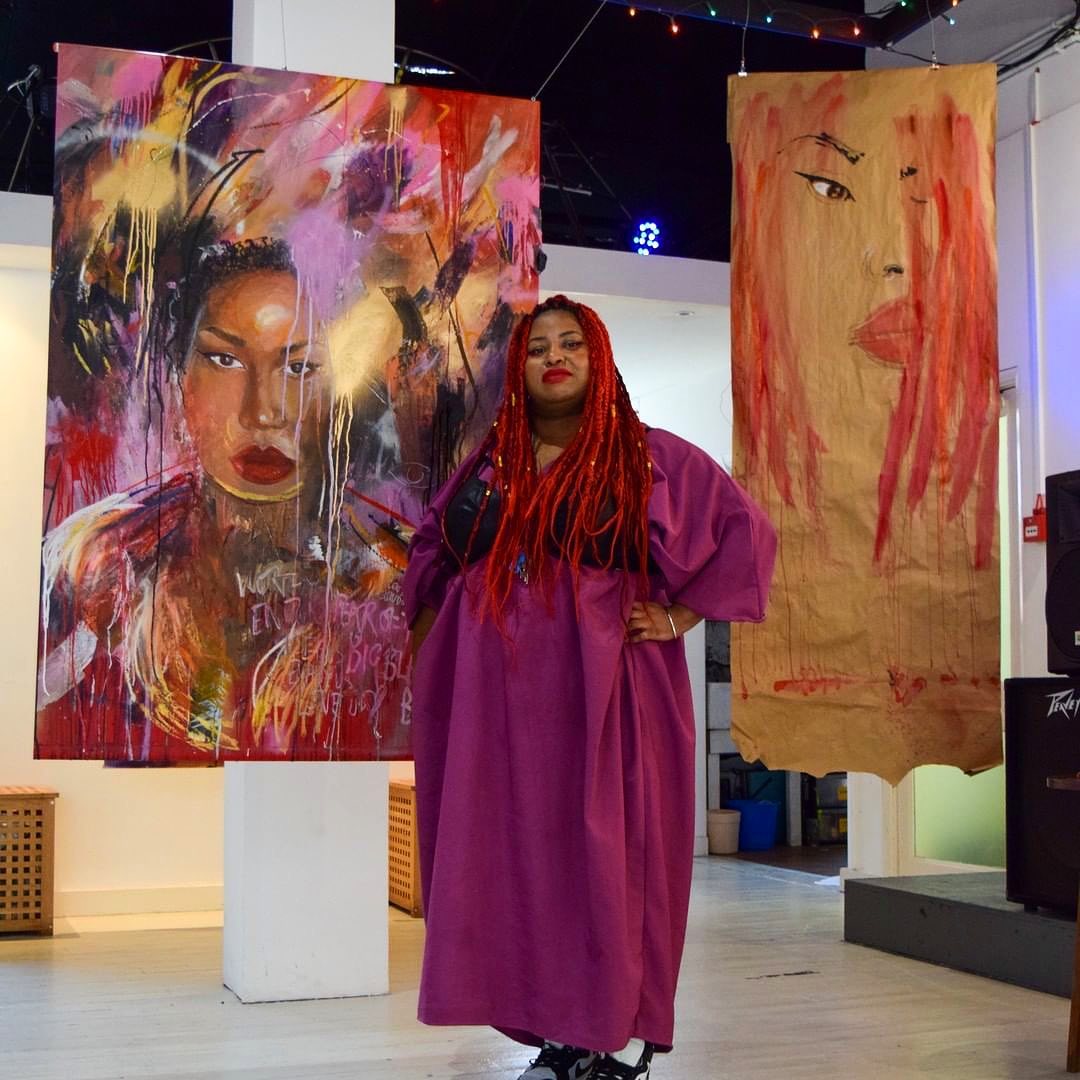 Honey Williams standing in front of some of her work
