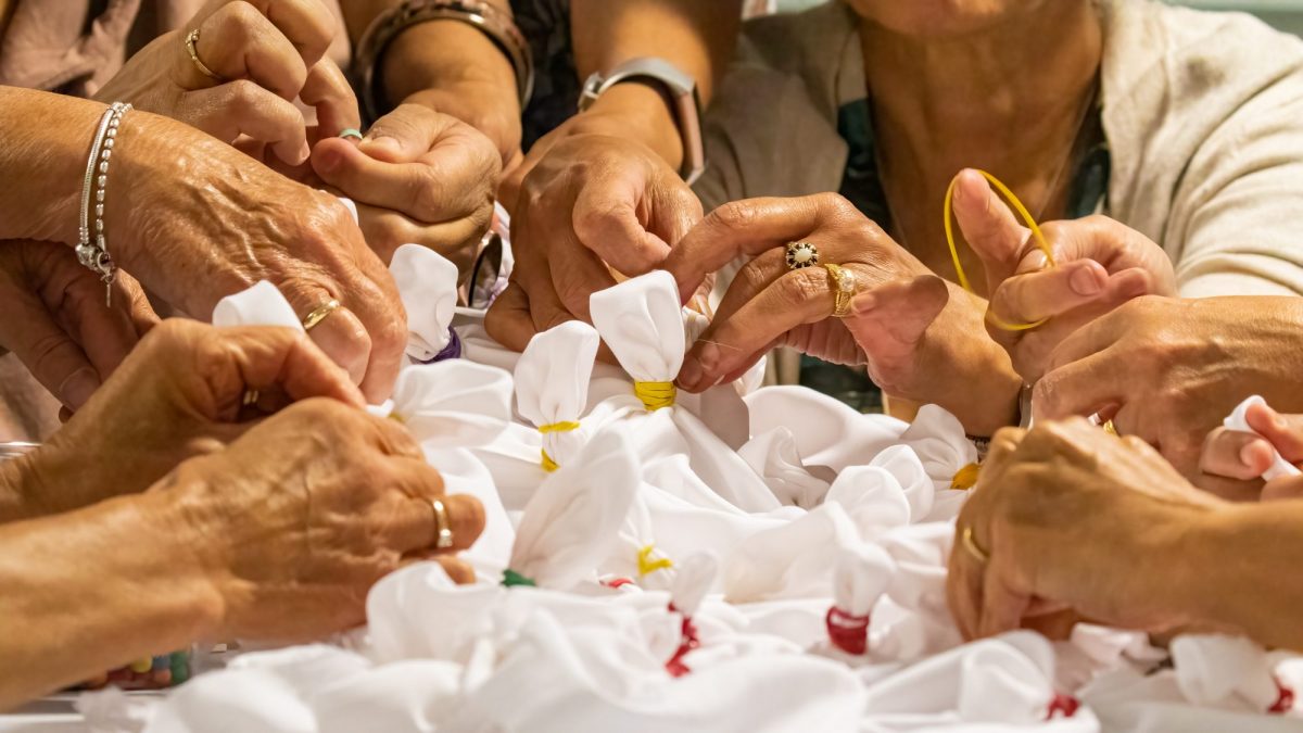 Multiple hands creating tie-dye in workshop