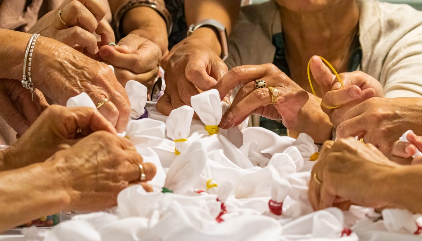 Hands making tie-dye textiles