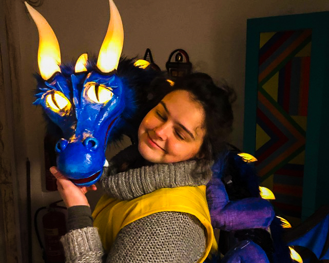 Artist Bryony McCombie Smith holding a puppet dragon