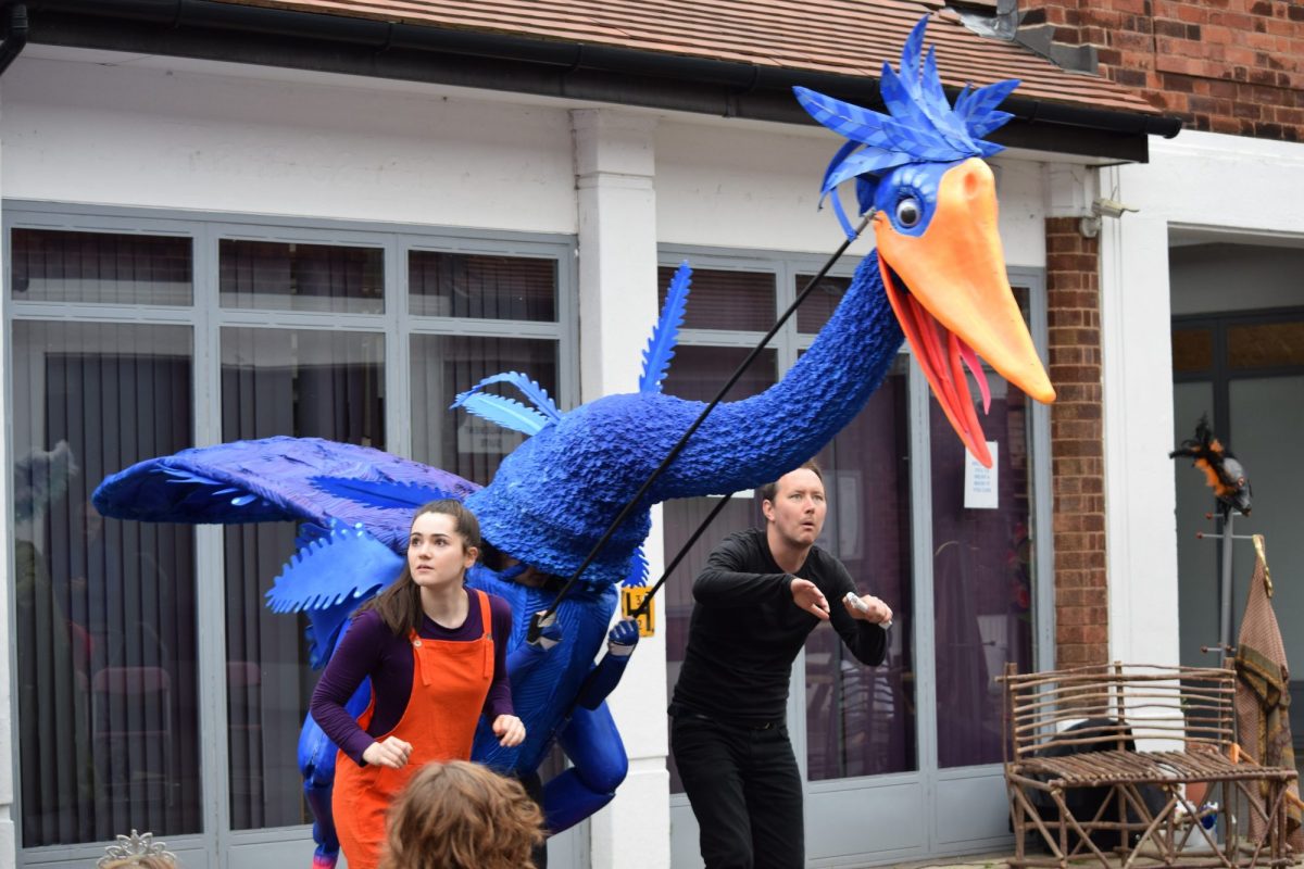 Giant bird-like puppet with two actors