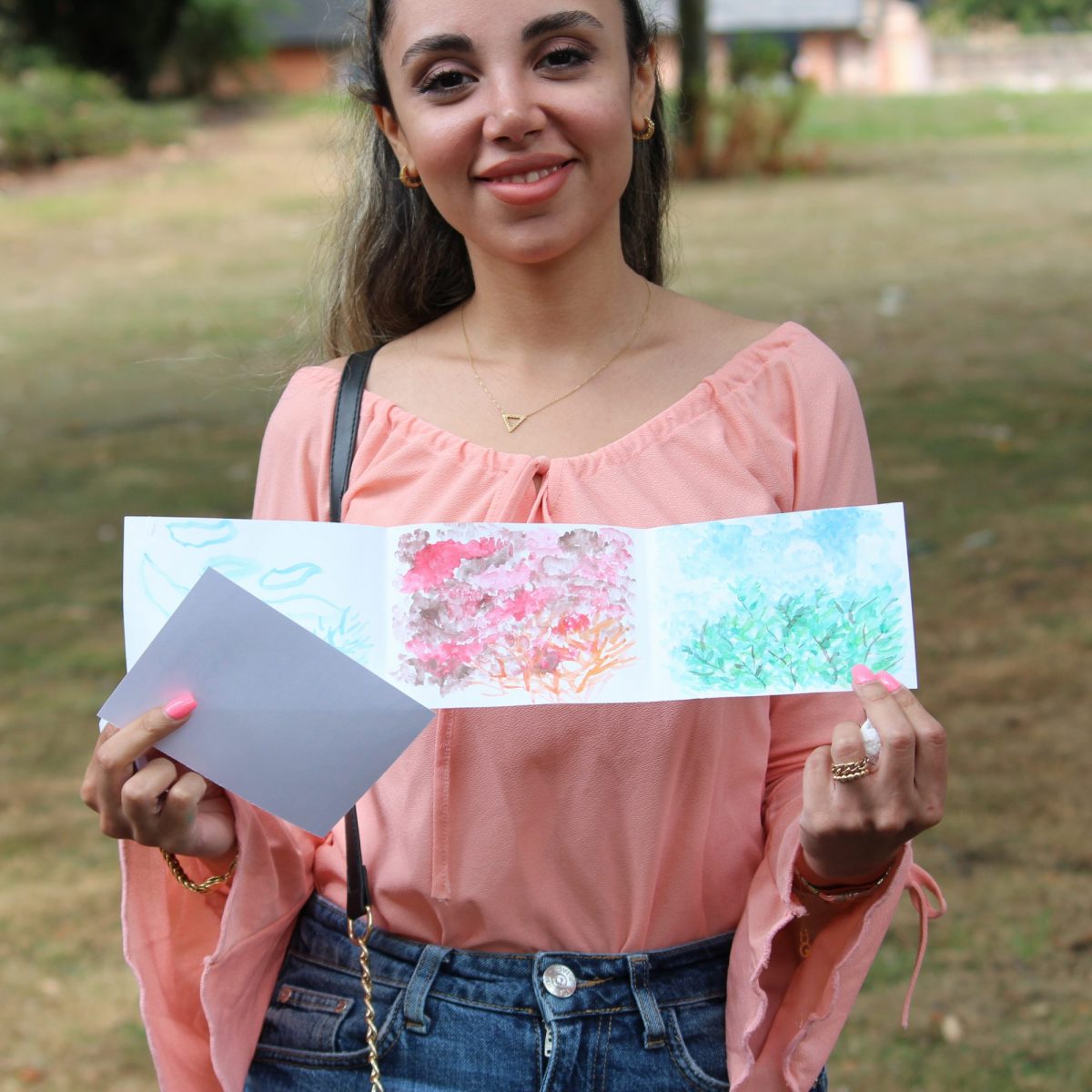 Young woman holds up a watercolour sketch