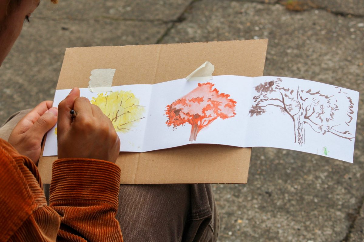 Painting watercolours of trees outdoors
