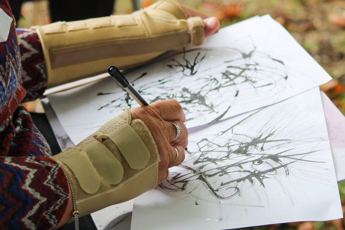 Woman in wrist braces paints with ink