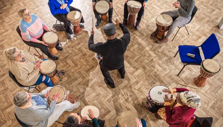 Drum circle in church hall, photographed from above.