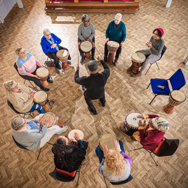 Drum circle in church hall, photographed from above.