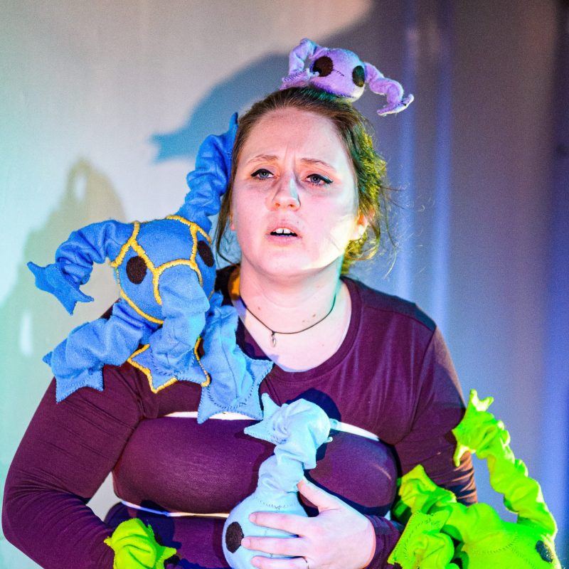 Izzy Hollis with wearable puppets representing Tourette's tics.