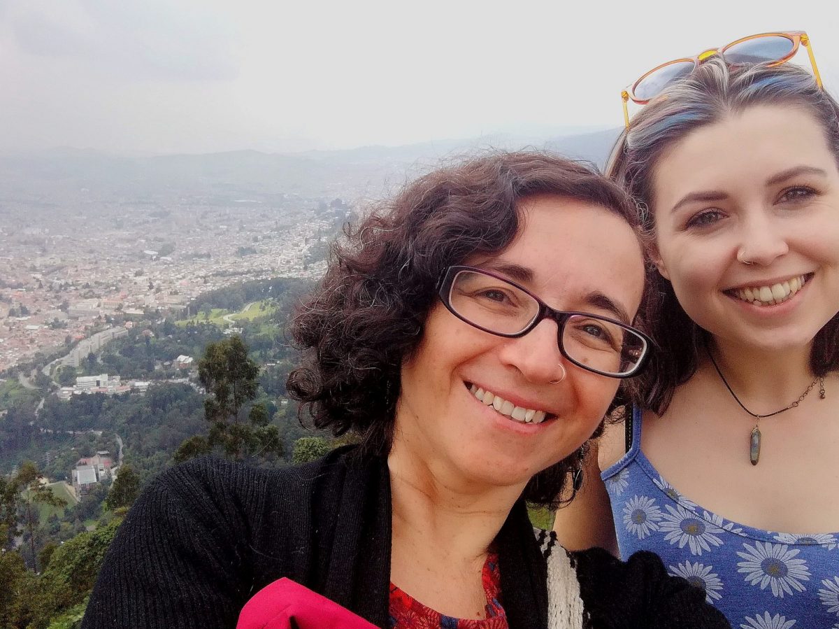 two women smiling on a hilltop