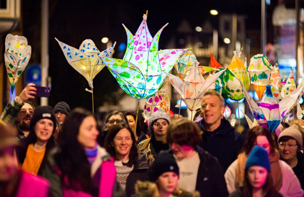People march through Nottingham street holding illuminated willow and tissue paper lanterns