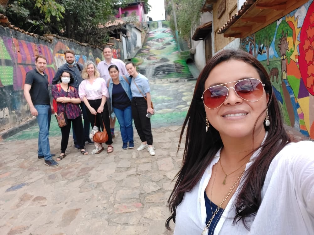 Selfie with a group in Honduras. The street, including steps, are decorated with colourful street art.