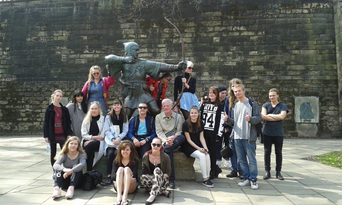 Group of people surrounding a statue of Robin Hood