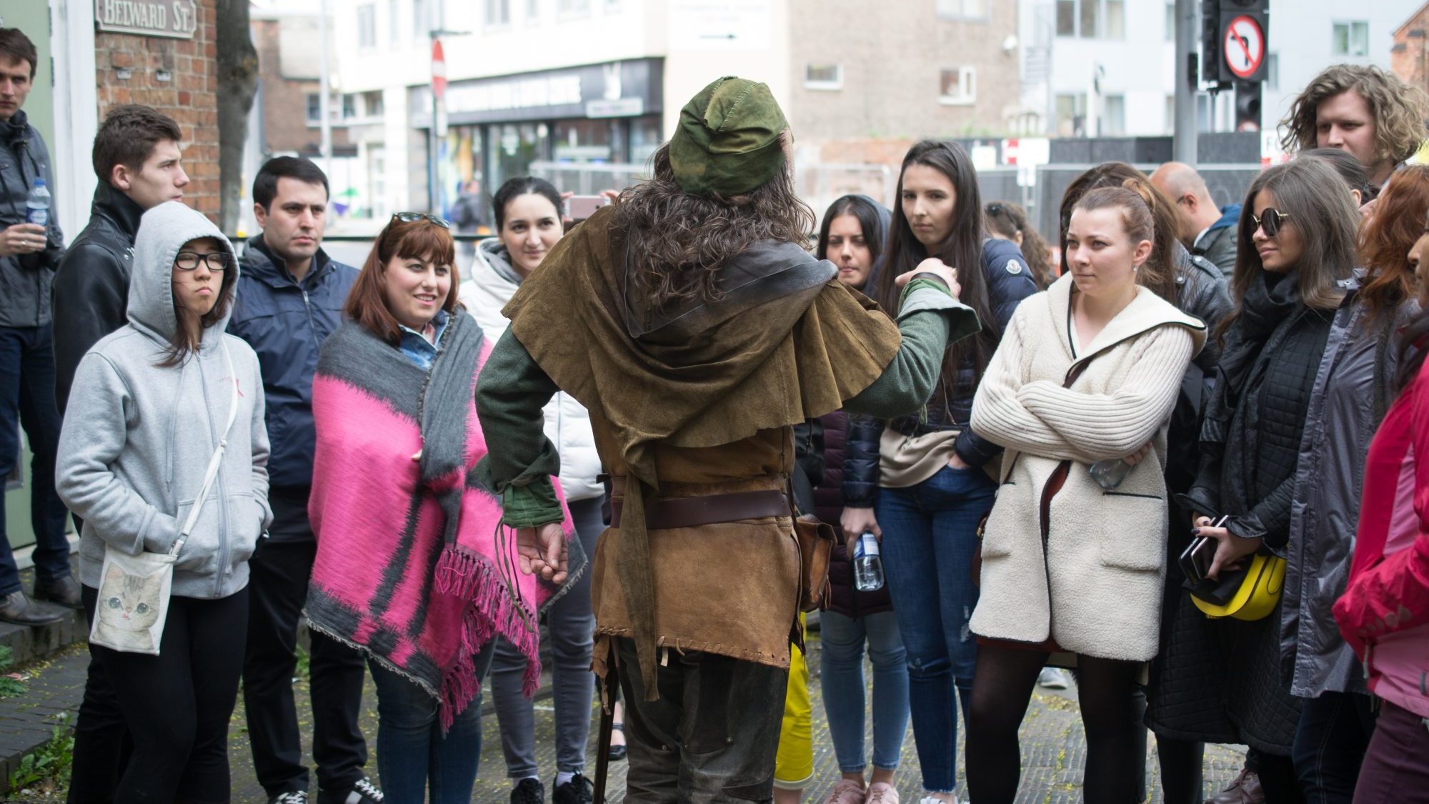 Group of people watching a Robin Hood impersonator 